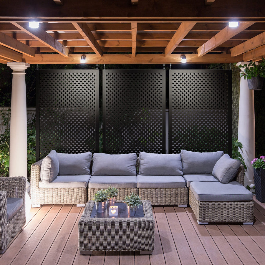 Black Deckorators lattice panels behind an outdoor sofa on a covered patio