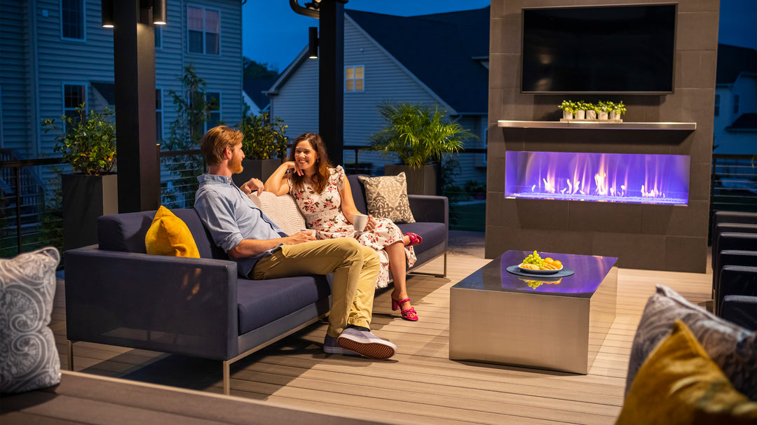 Two People Sit on a deck in front with Key-Link railing in the background