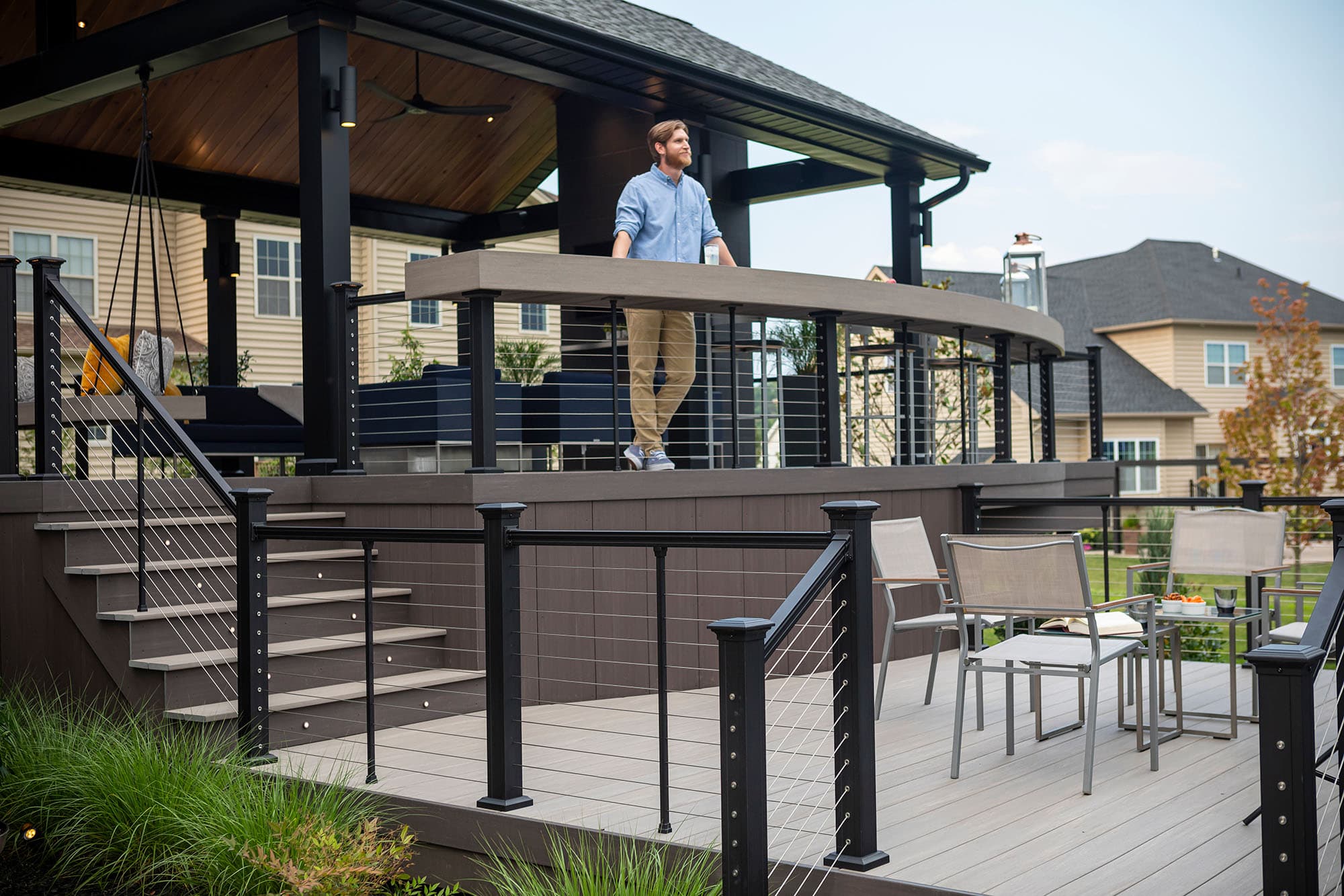 Key-Link American Series Horizontal cable railing used ano a large deck. A man stands looking at his yard.
