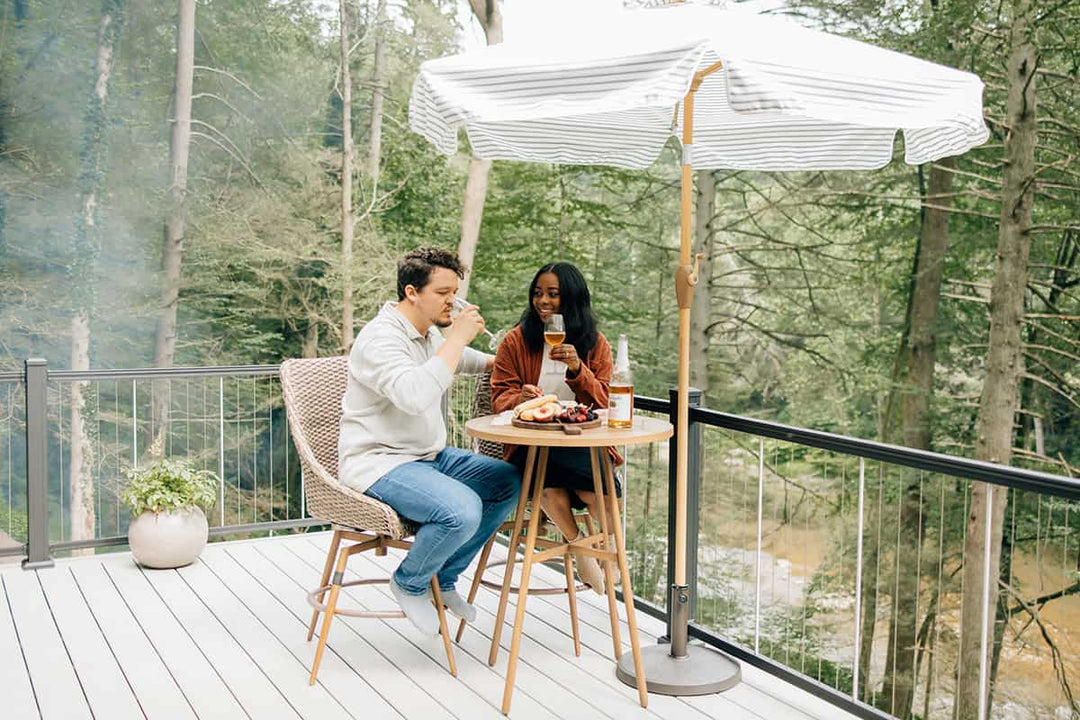 A couple enjoys sitting on a deck that features the Key-Link Vertical Cable Railing System