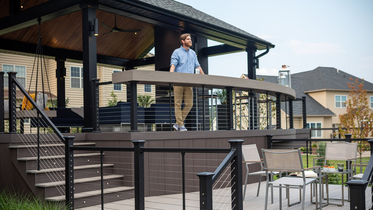A man stands on an outdoor deck featuring Key-link Horizontal Cable Railing