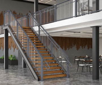 Staircase with wooden steps and aluminum vertical cable railing railing in a modern indoor setting with tables and chairs.