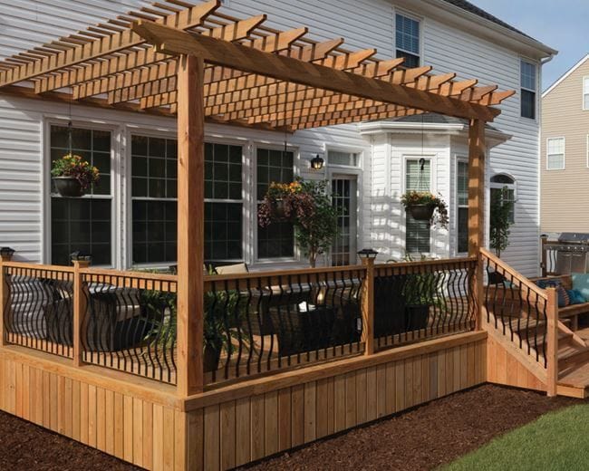 Deckorators Baroque aluminum balusters in wood railing under a pergola